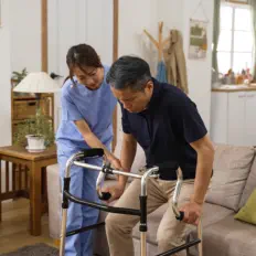 caregiver assisting an elderly walking